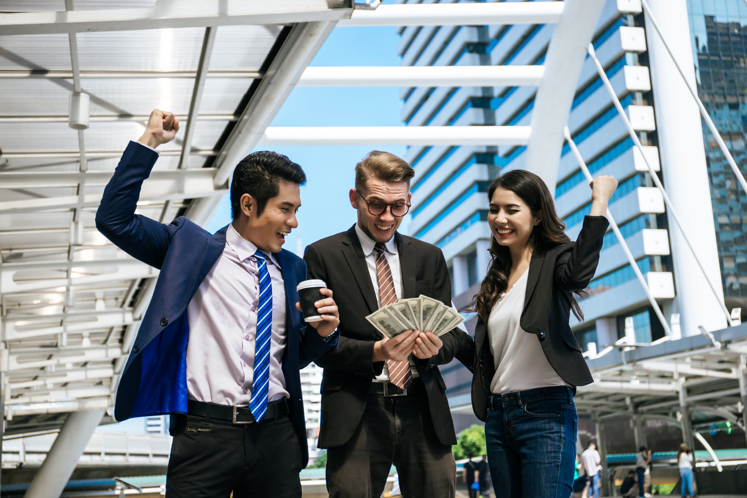 A group of entry-level customer service representatives celebrating with money